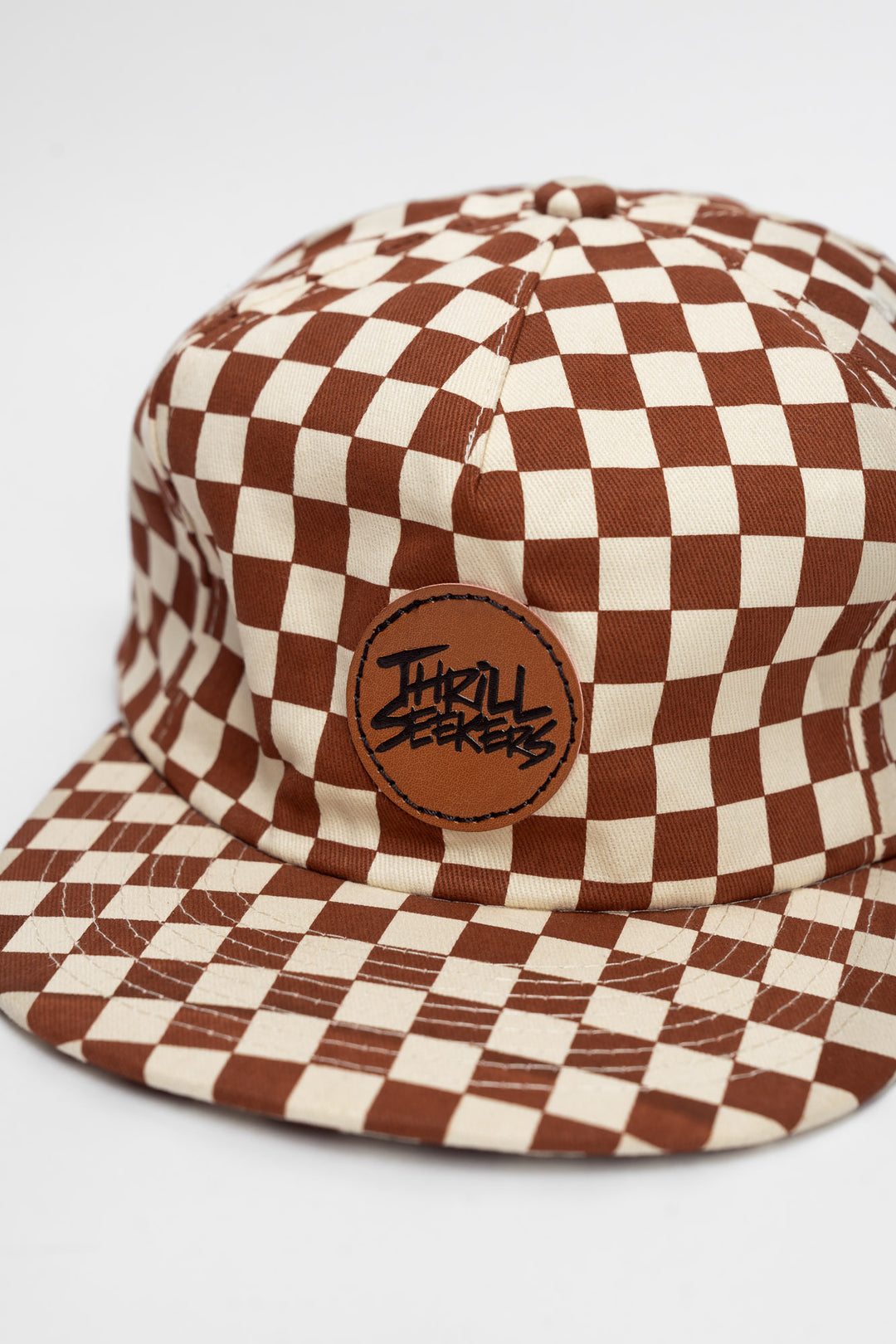 Checkered cap with rusty clay and off-white on a white background