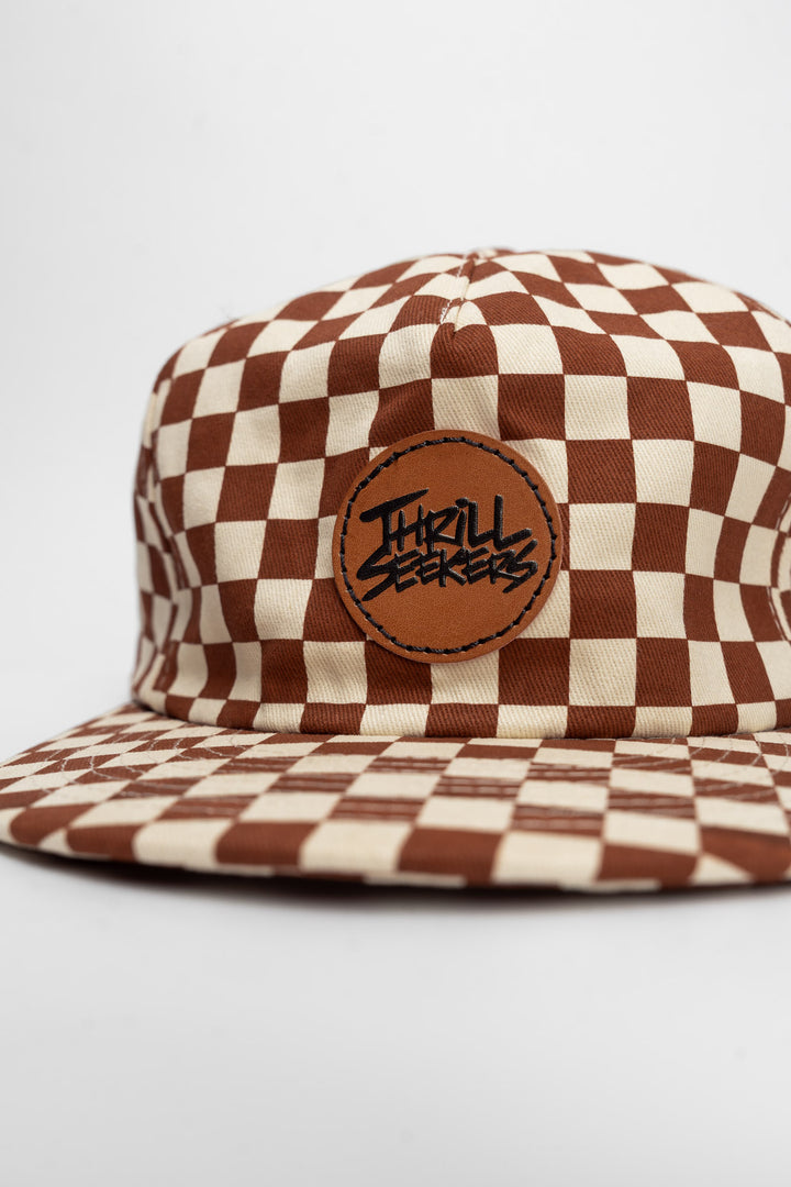 Checkered cap with rusty clay and off-white on a white background