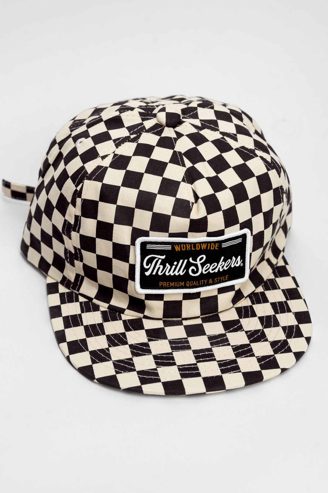 Checkered cap with 'Thrill Seekers' logo on a white background