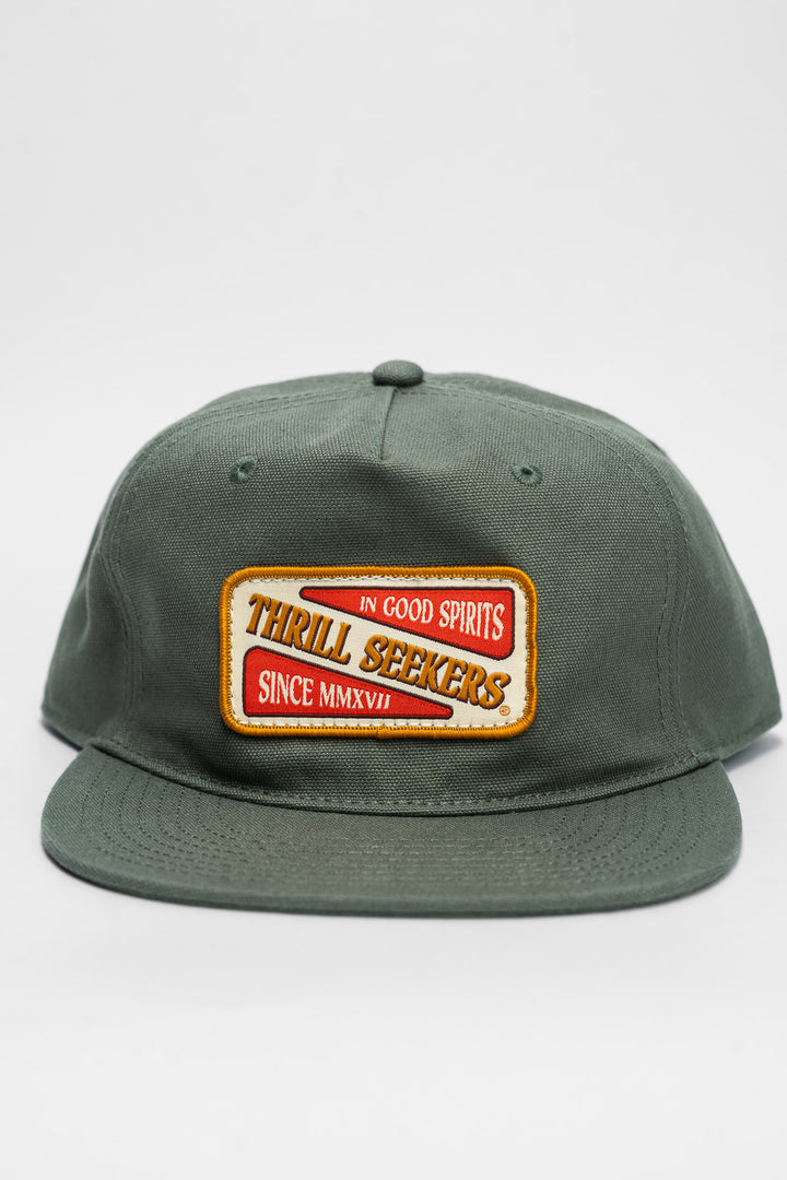 Green cap with a 'Thrill Seekers' patch on a white background