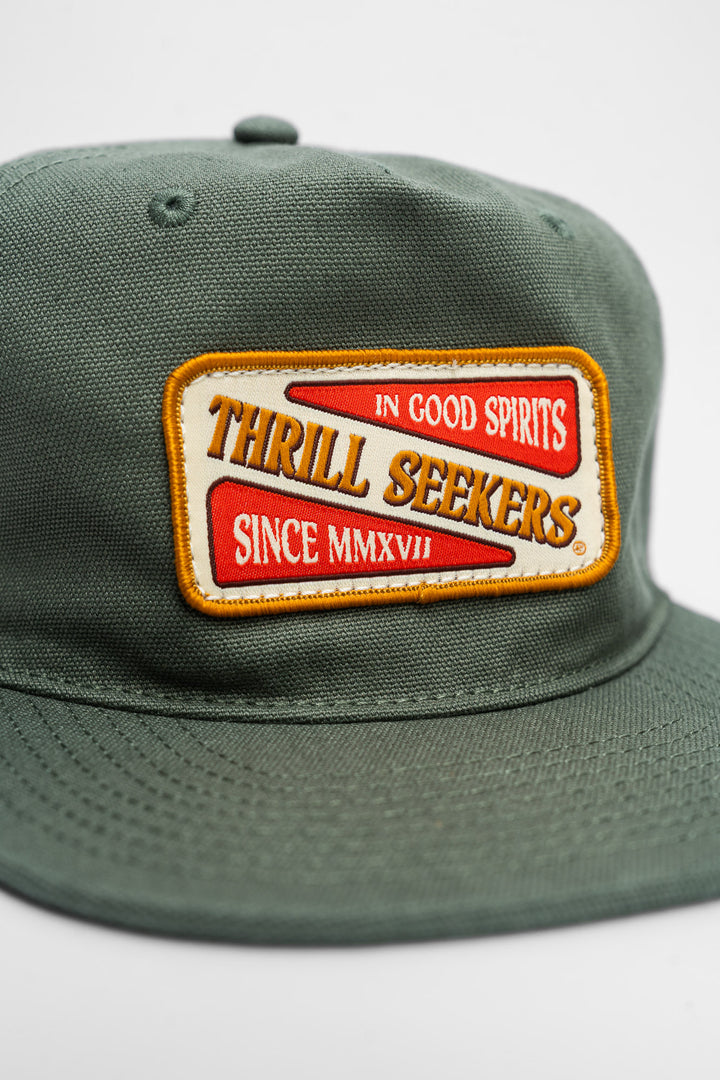 Green cap with a 'Thrill Seekers' patch on a white background