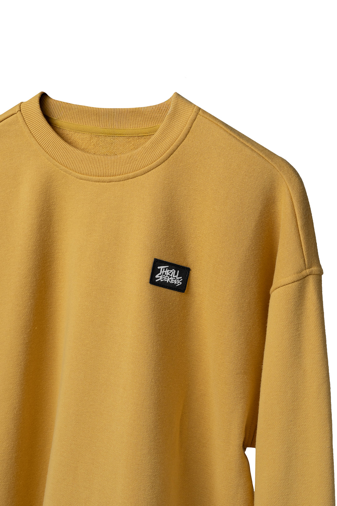 Yellow sweatshirt with a black logo patch on a white background