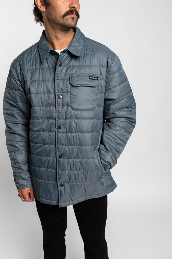 Man wearing a blue quilted jacket on a white background