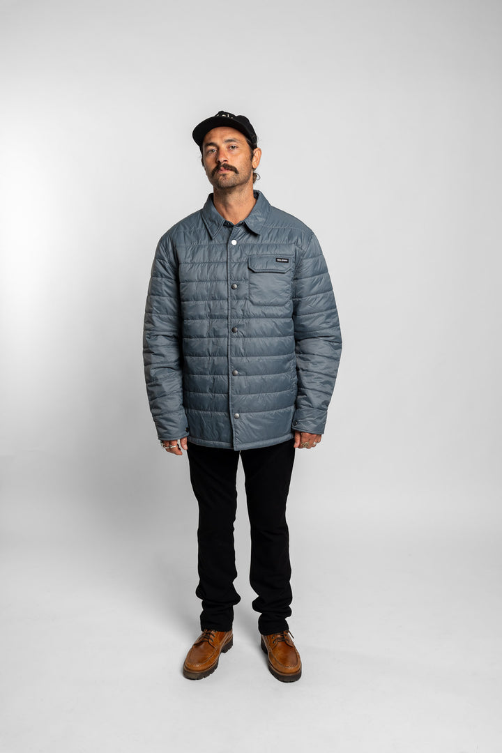 Man wearing a blue quilted jacket on a white background