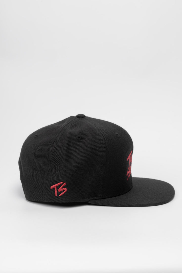 Black snapback hat with 'Thrill Seekers' logo in cardinal red