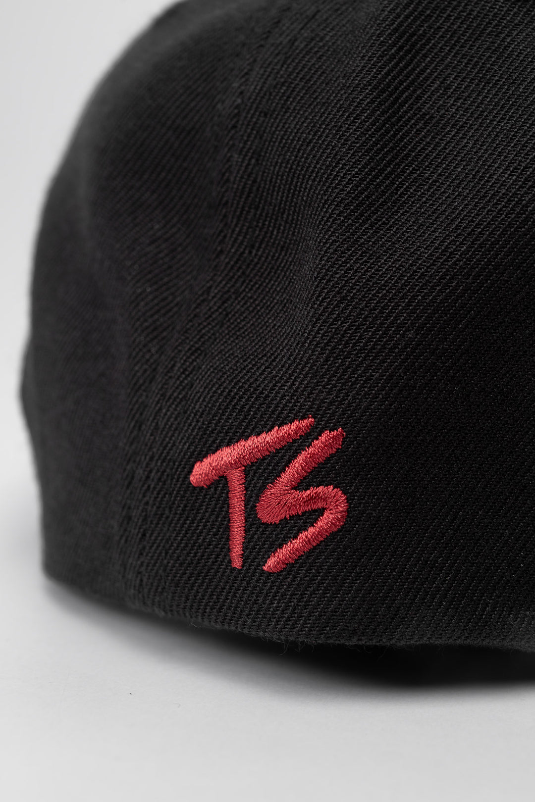 Black snapback hat with 'Thrill Seekers' logo in cardinal red