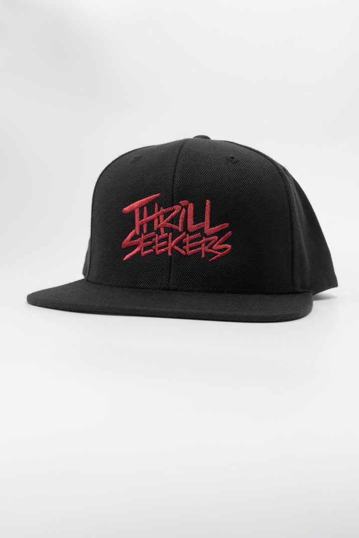 Black snapback hat with 'Thrill Seekers' logo in cardinal red