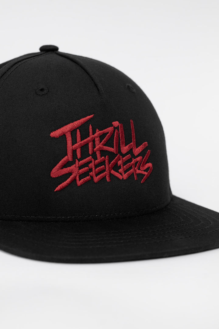 Black cap with cardinal red 'Thrill Seekers' text on a white background