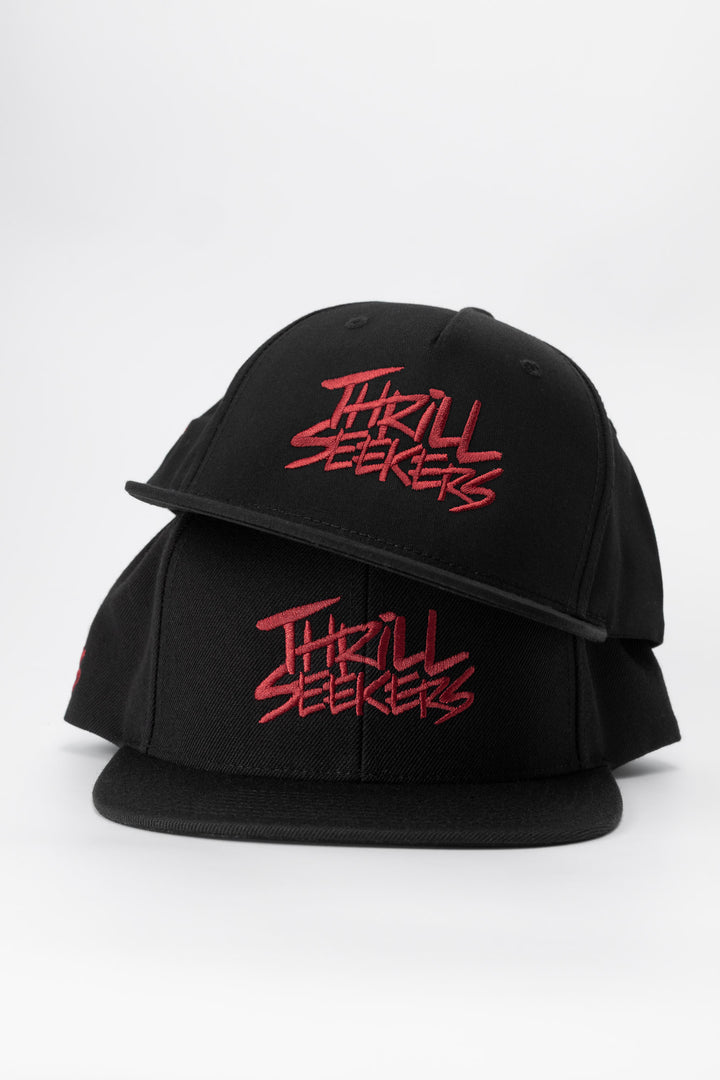 Black cap with cardinal red 'Thrill Seekers' text on a white background