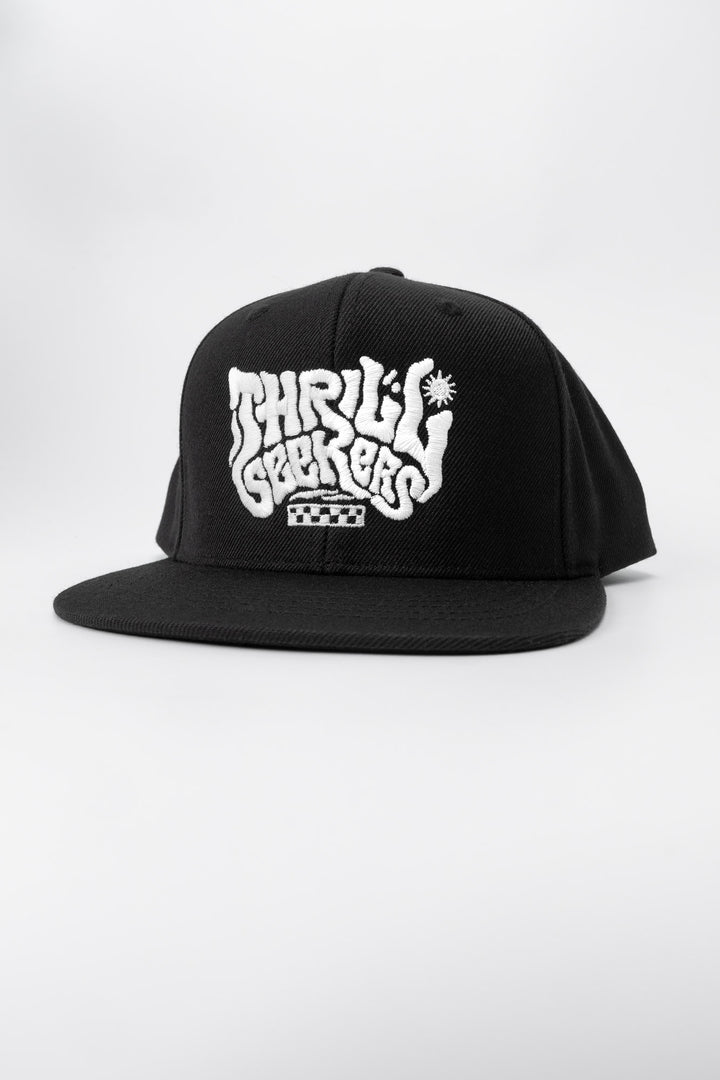 Kids black cap with 'Thrill Seekers' white logo on a white background