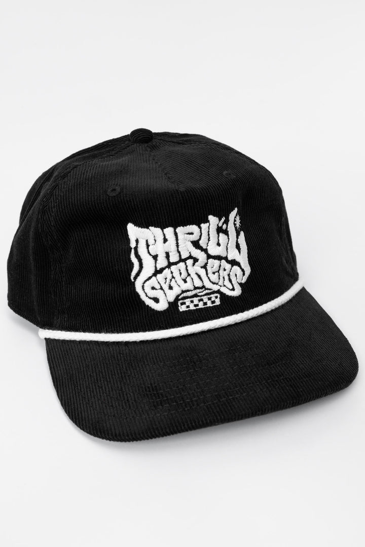 Black cap corduroy with 'Thrill Seekers' smokin' white logo on a white background