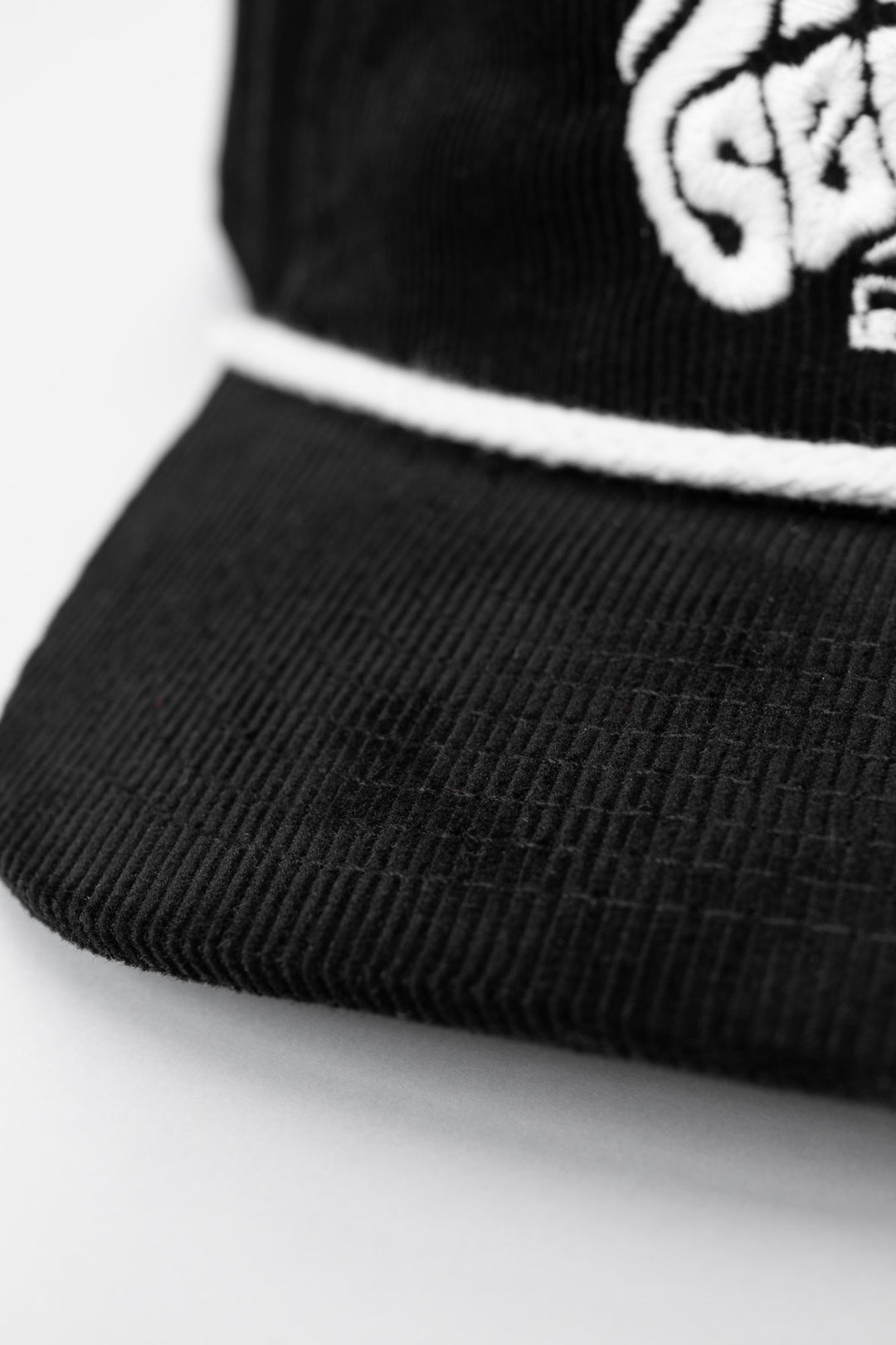 Black cap corduroy with 'Thrill Seekers' smokin' white logo on a white background