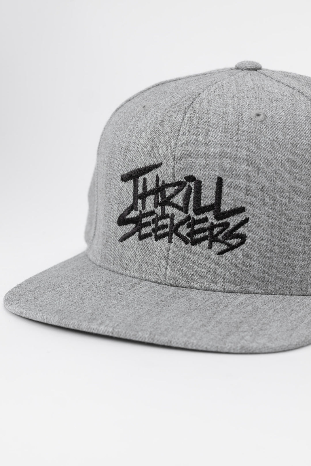 Grey snapback hat with 'Thrill Seekers' logo in black
