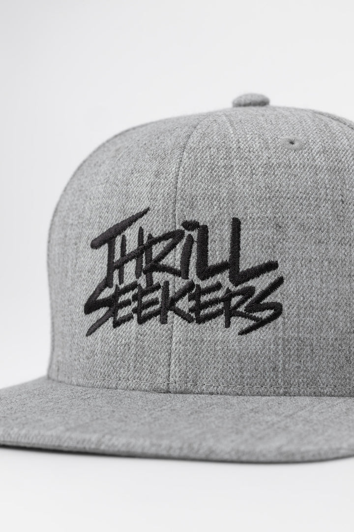 Grey cap with black 'Thrill Seekers' logo on a white background