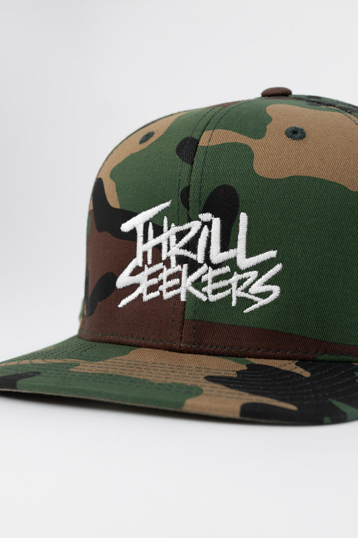 Camo snapback hat with 'Thrill Seekers' logo in white
