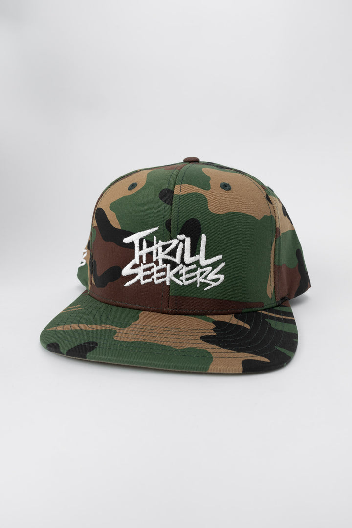 Camo snapback hat with 'Thrill Seekers' logo in white