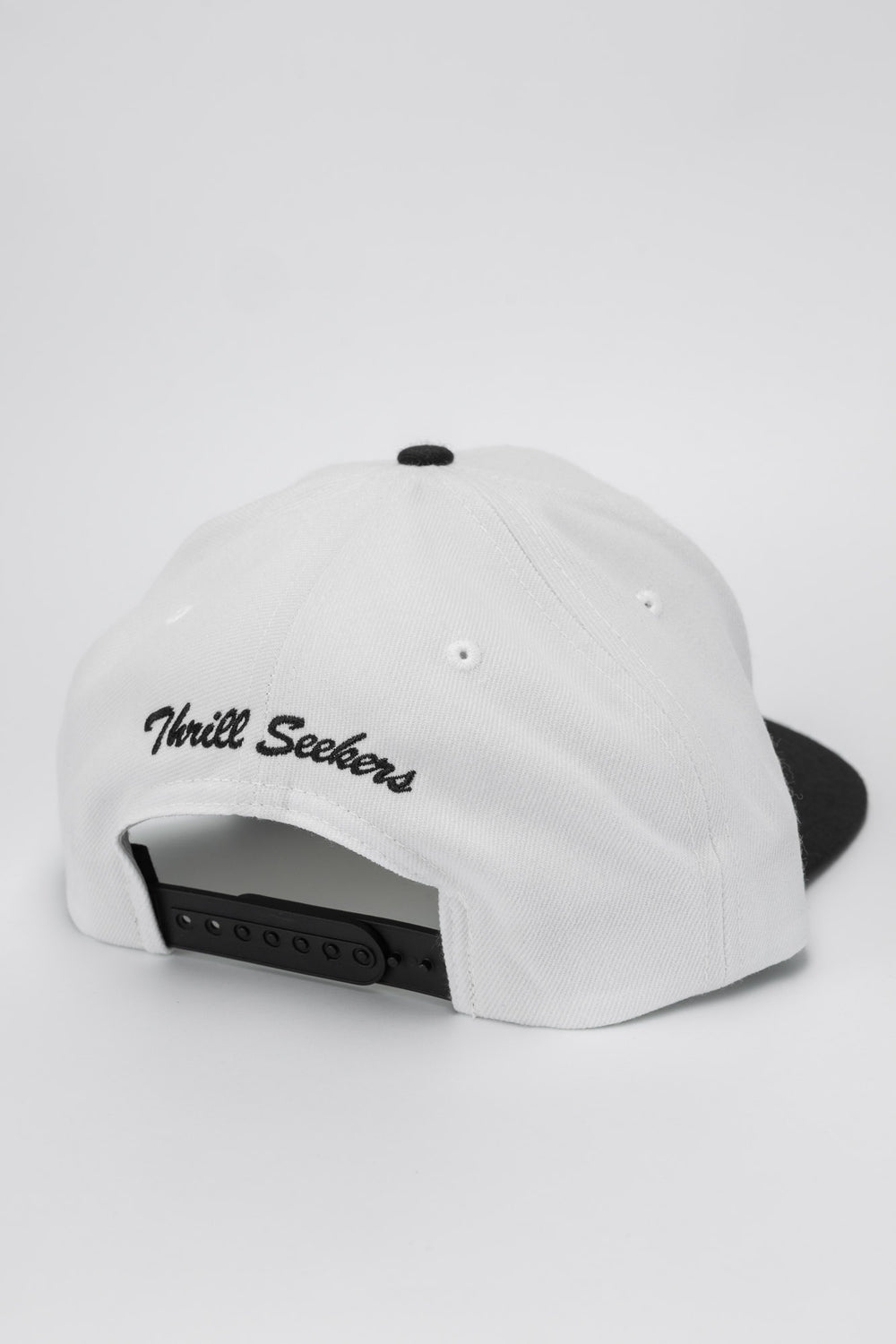 White and black snapback with 'Thrill Seekers' logo in black
