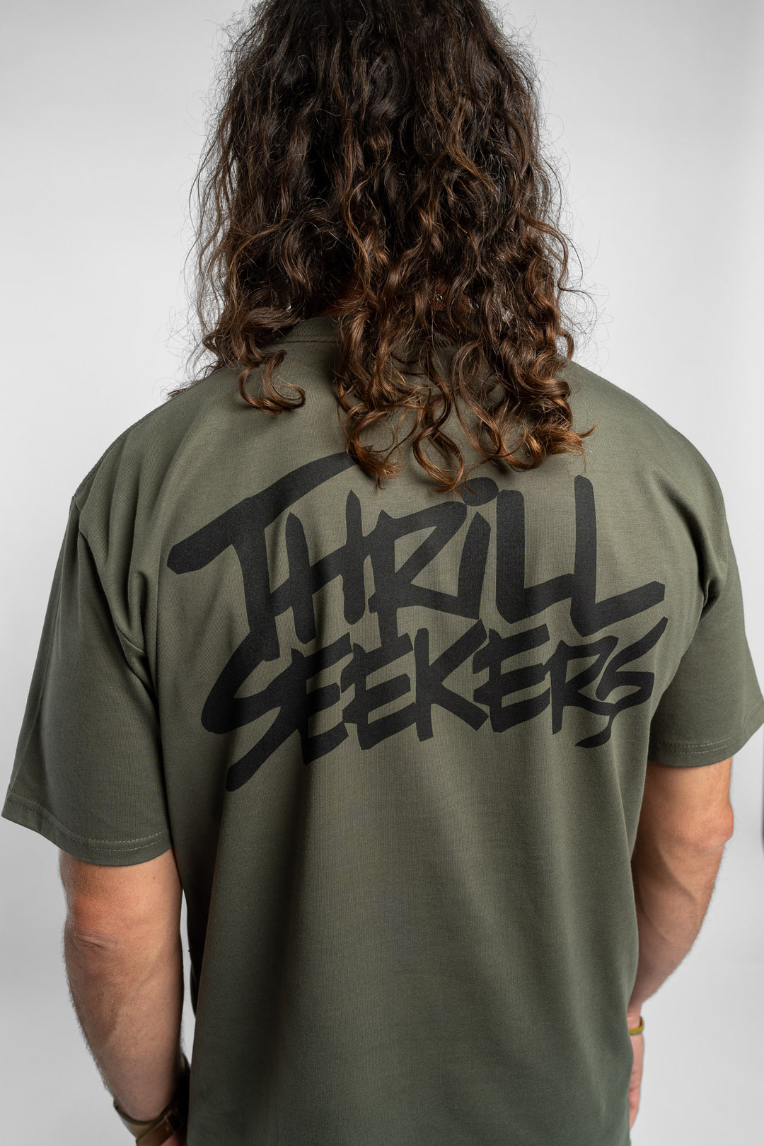 Person wearing a cypress tee with 'Thrill Seekers' logo in black