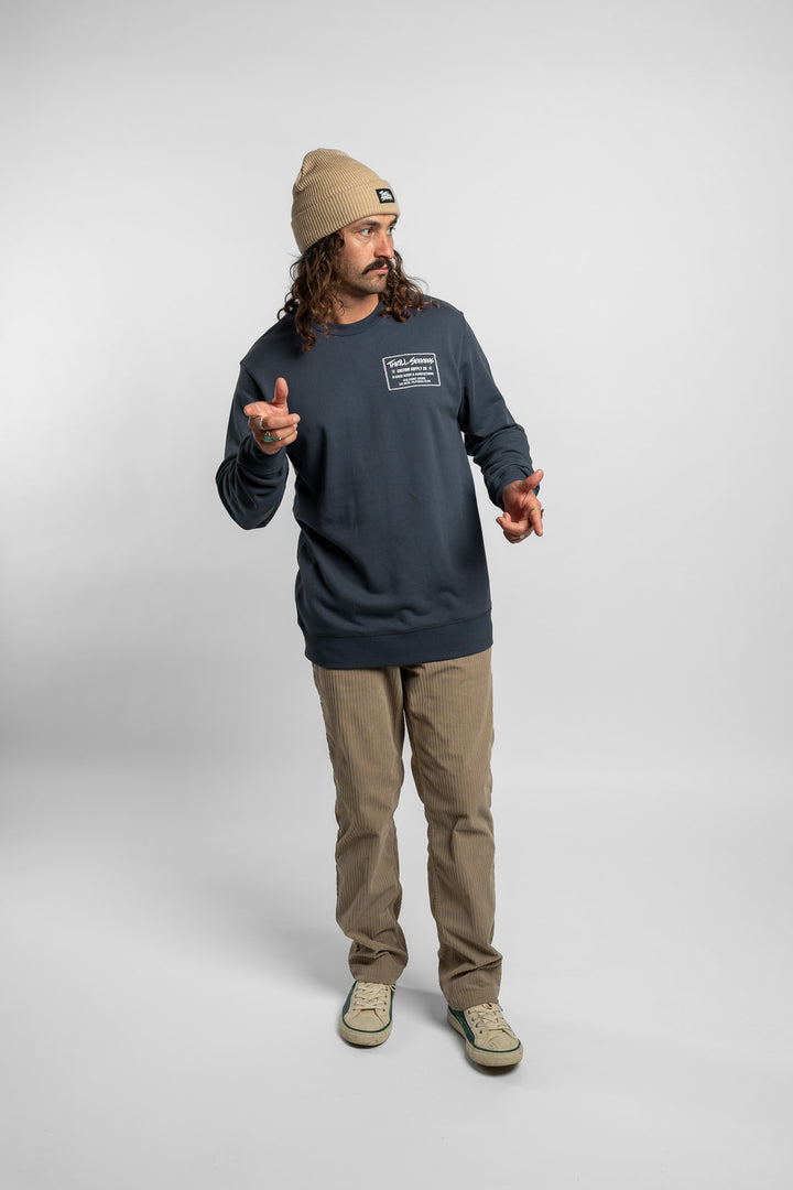 Person wearing a blue crewneck with 'Thrill Seekers' workman logo