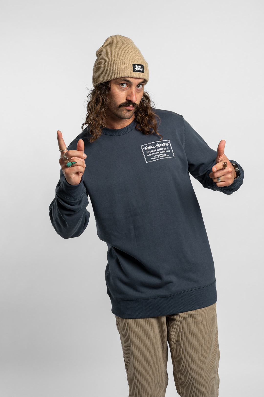 Person wearing a blue crewneck with 'Thrill Seekers' workman logo