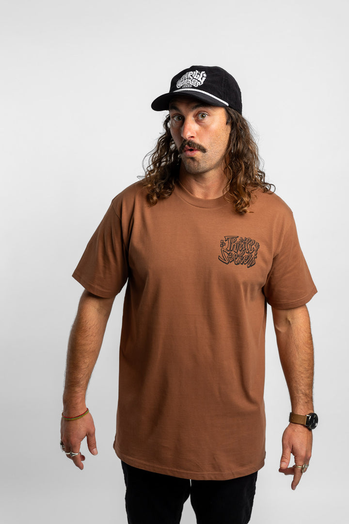 Person wearing cocoa tee with 'Thrill Seekers' scribe logo