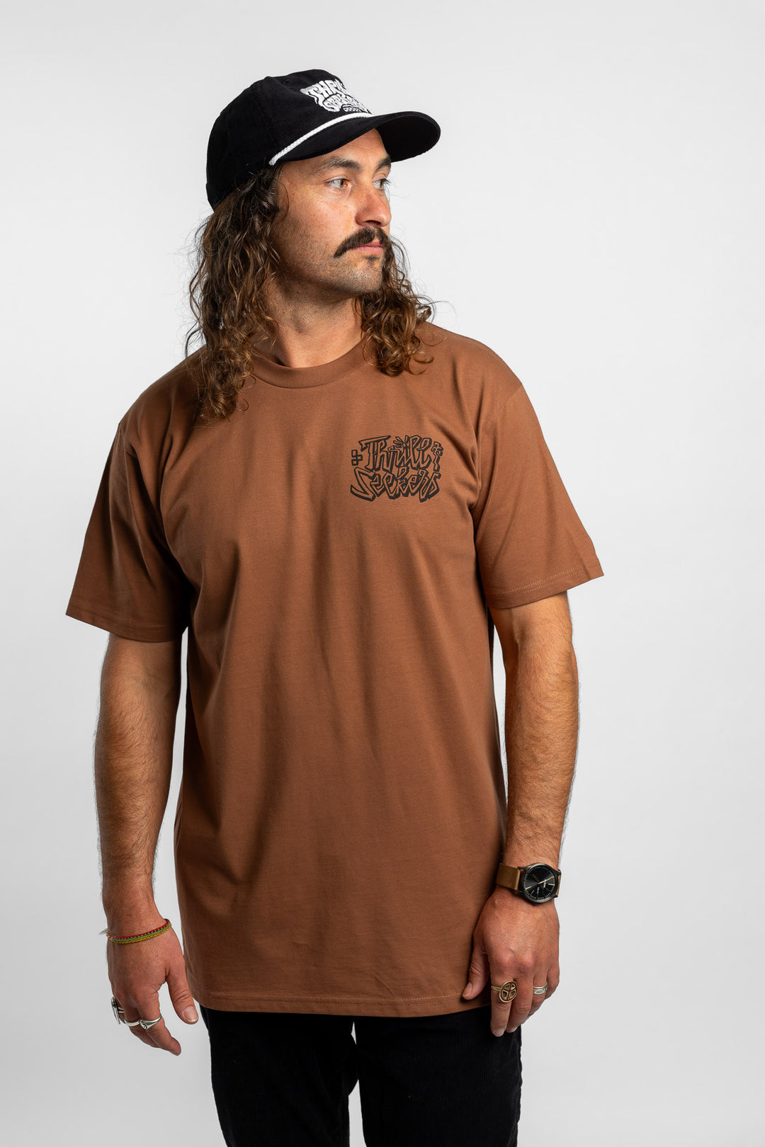 Person wearing cocoa tee with 'Thrill Seekers' scribe logo