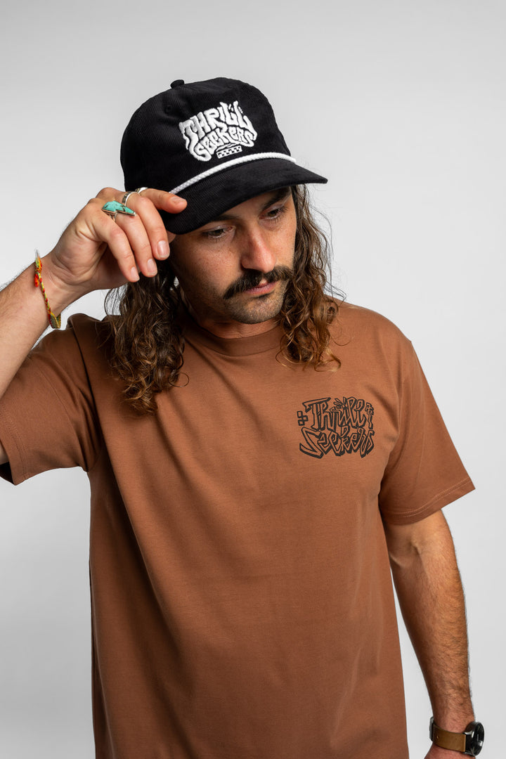 Person wearing cocoa tee with 'Thrill Seekers' scribe logo