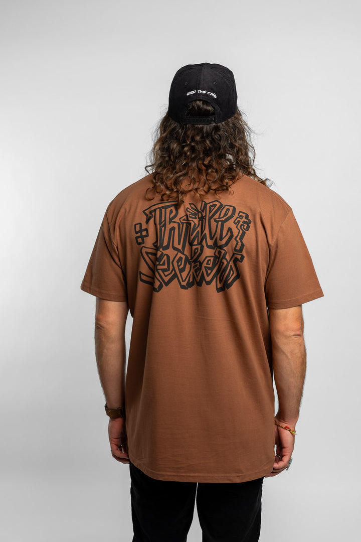 Person wearing cocoa tee with 'Thrill Seekers' scribe logo