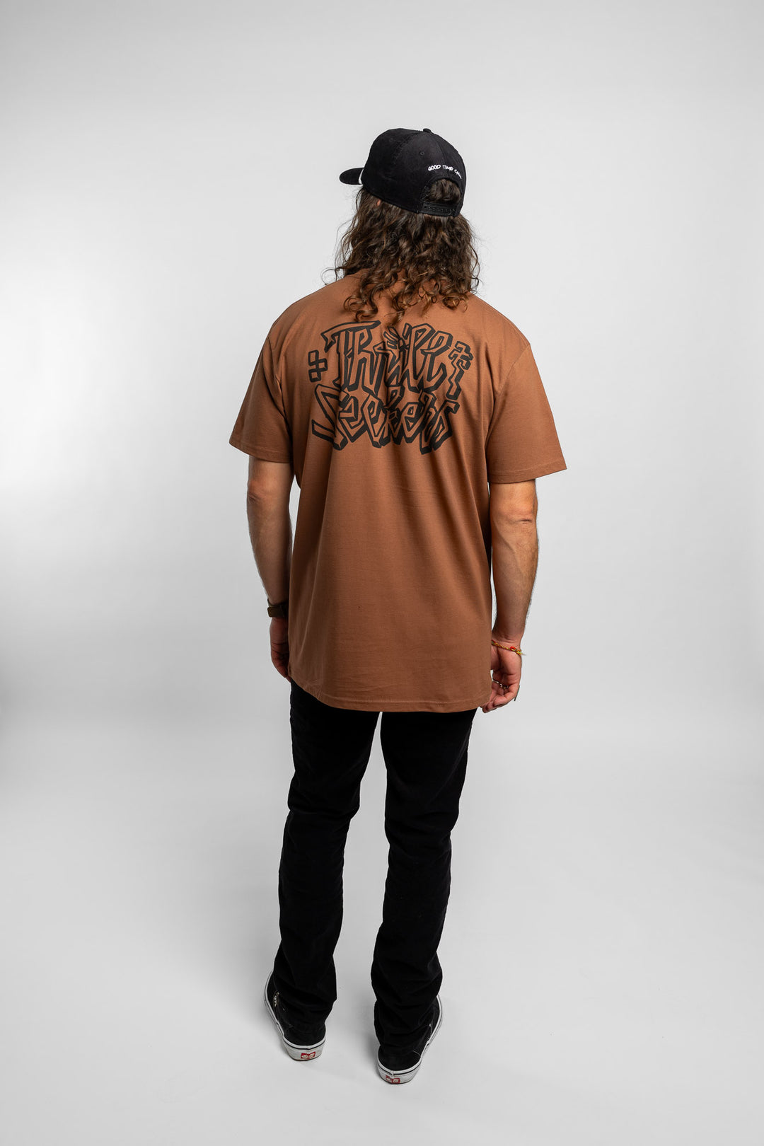 Person wearing cocoa tee with 'Thrill Seekers' scribe logo