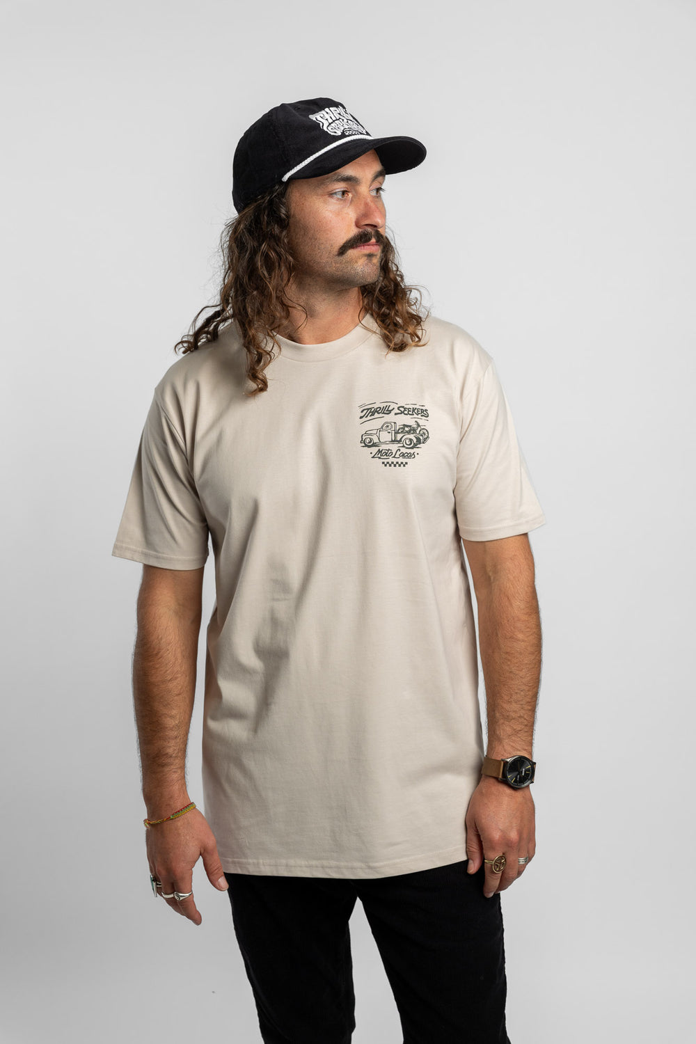 Person wearing bone tee with 'Thrill Seekers' moto locos logo in green