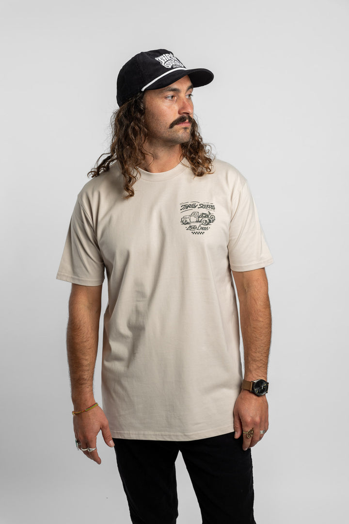 Person wearing bone tee with 'Thrill Seekers' moto locos logo in green