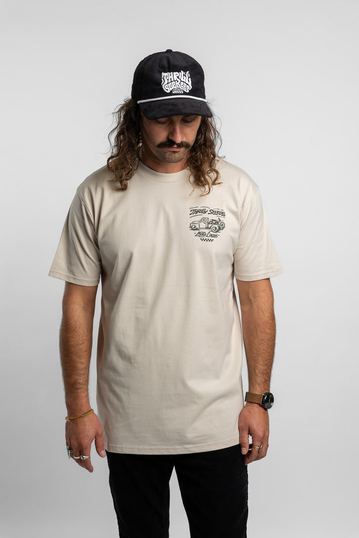 Person wearing bone tee with 'Thrill Seekers' moto locos logo in green