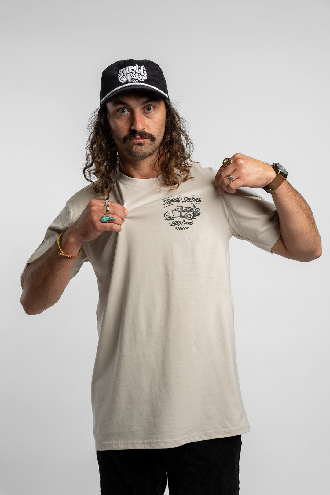 Person wearing bone tee with 'Thrill Seekers' moto locos logo in green