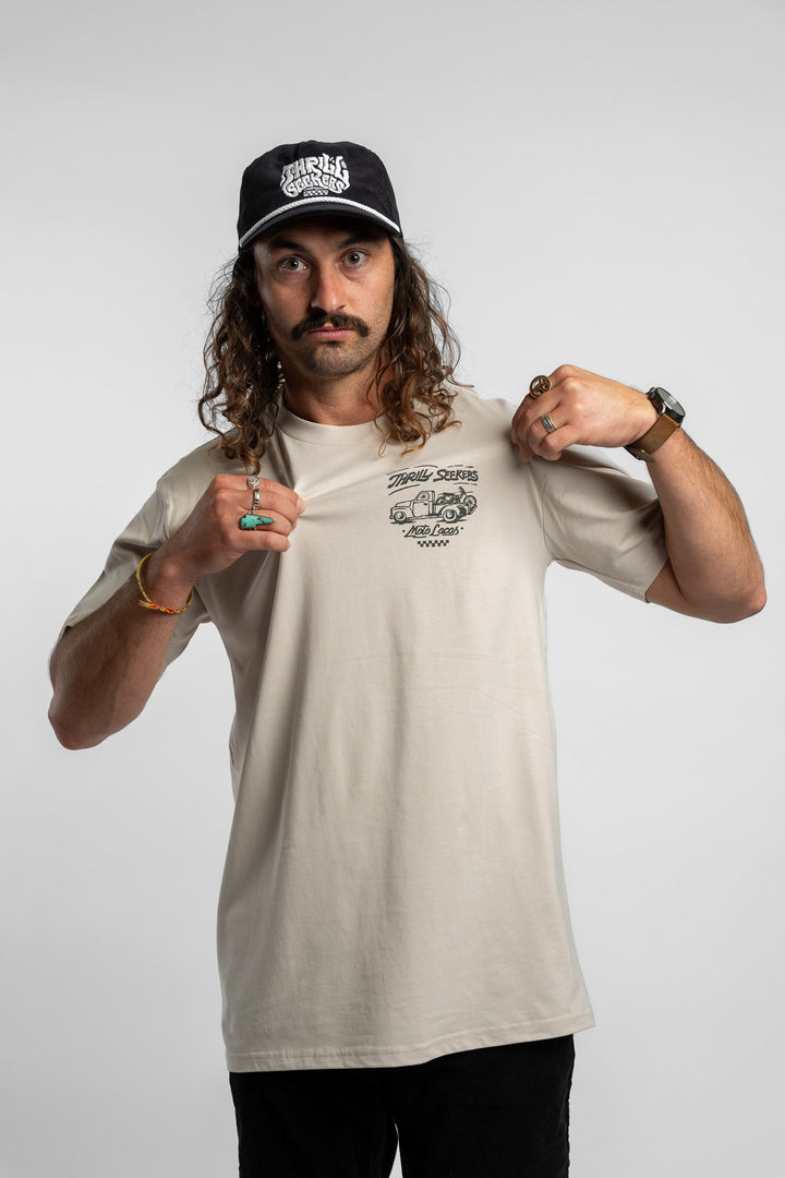 Person wearing bone tee with 'Thrill Seekers' moto locos logo in green