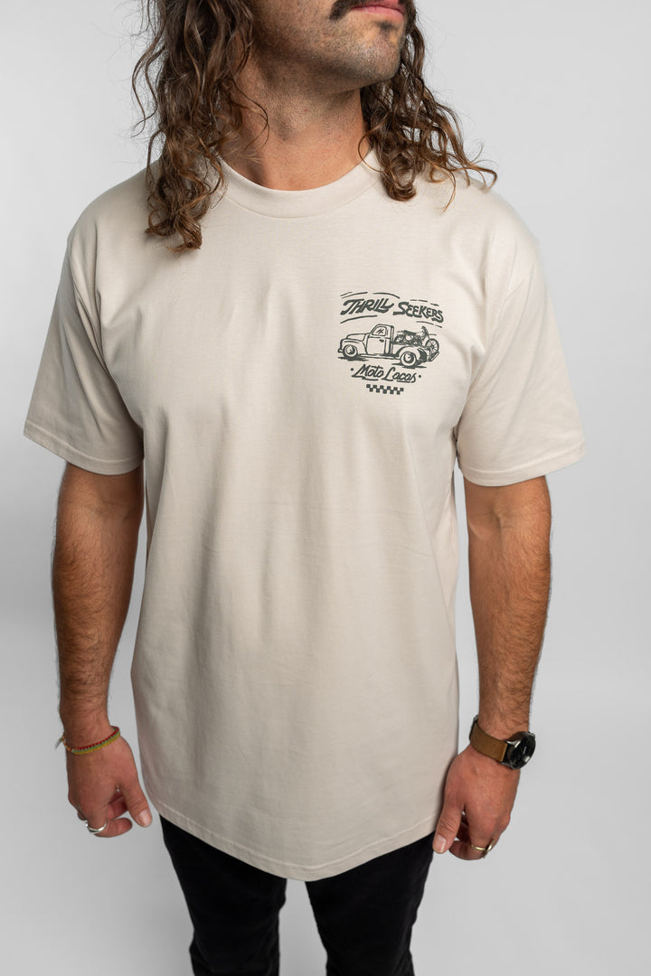 Person wearing bone tee with 'Thrill Seekers' moto locos logo in green