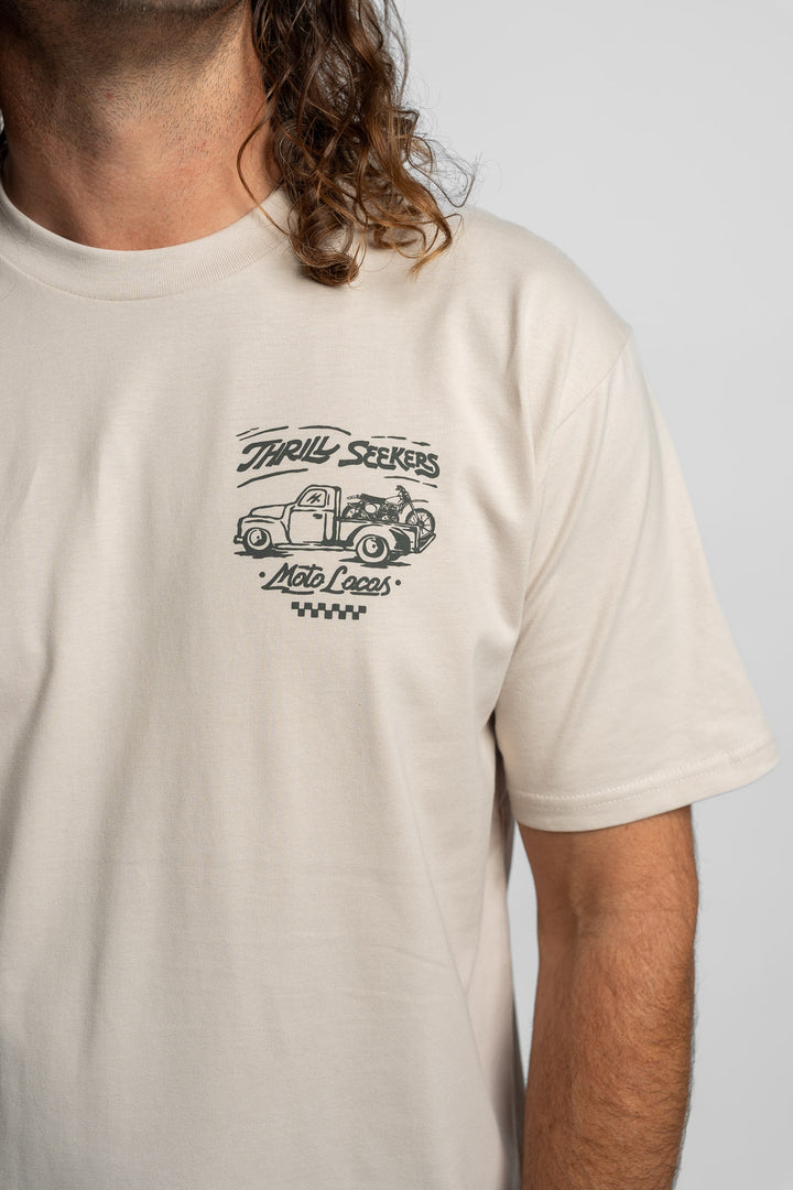 Person wearing bone tee with 'Thrill Seekers' moto locos logo in green