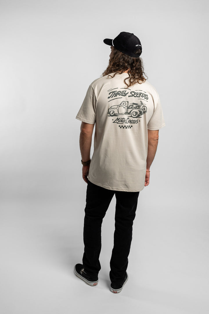 Person wearing bone tee with 'Thrill Seekers' moto locos logo in green