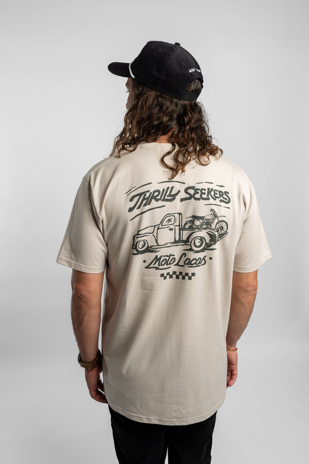 Person wearing bone tee with 'Thrill Seekers' moto locos logo in green