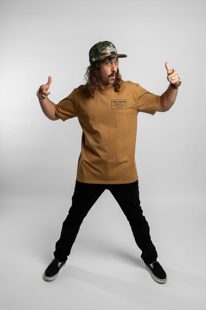 Person wearing a camel tee with a 'Thrill Seekers' workman logo