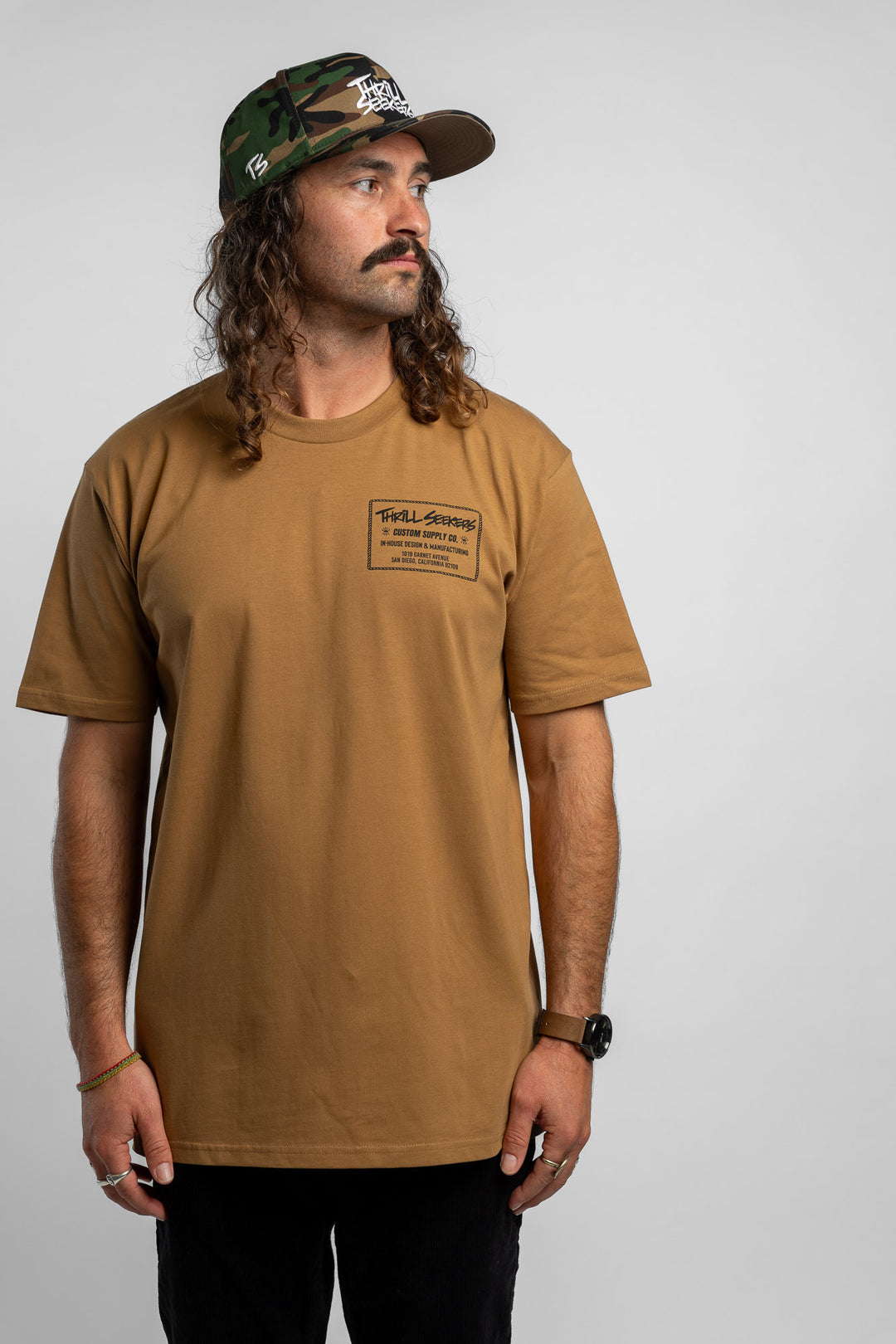 Person wearing a camel tee with a 'Thrill Seekers' workman logo