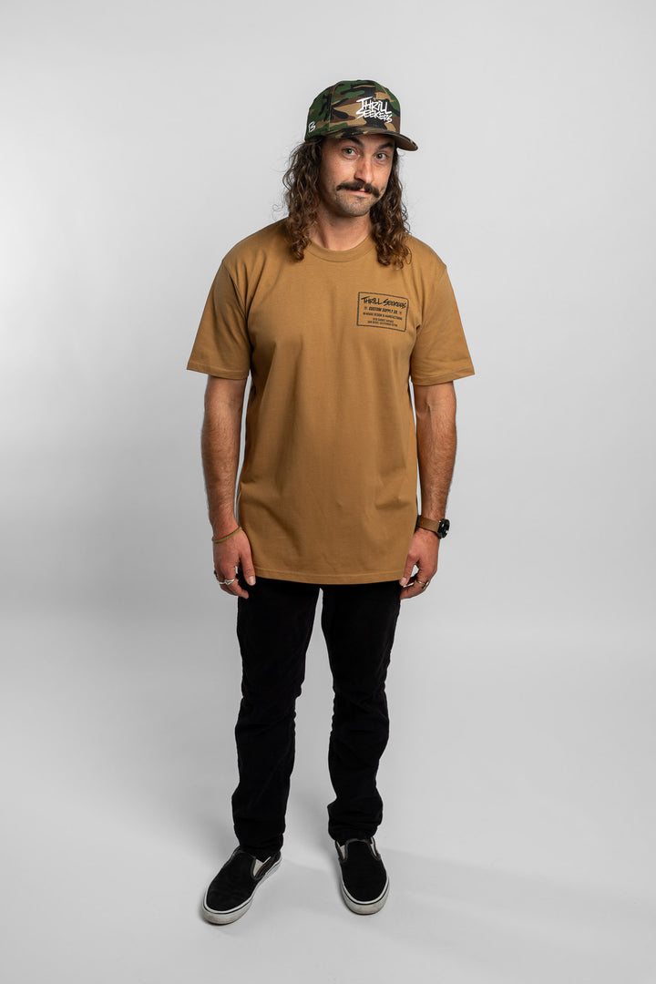 Person wearing a camel tee with a 'Thrill Seekers' workman logo