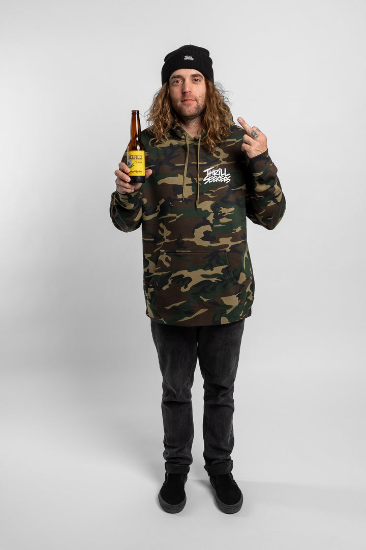 Person wearing camo hoodie with 'Thrill Seekers' logo in white