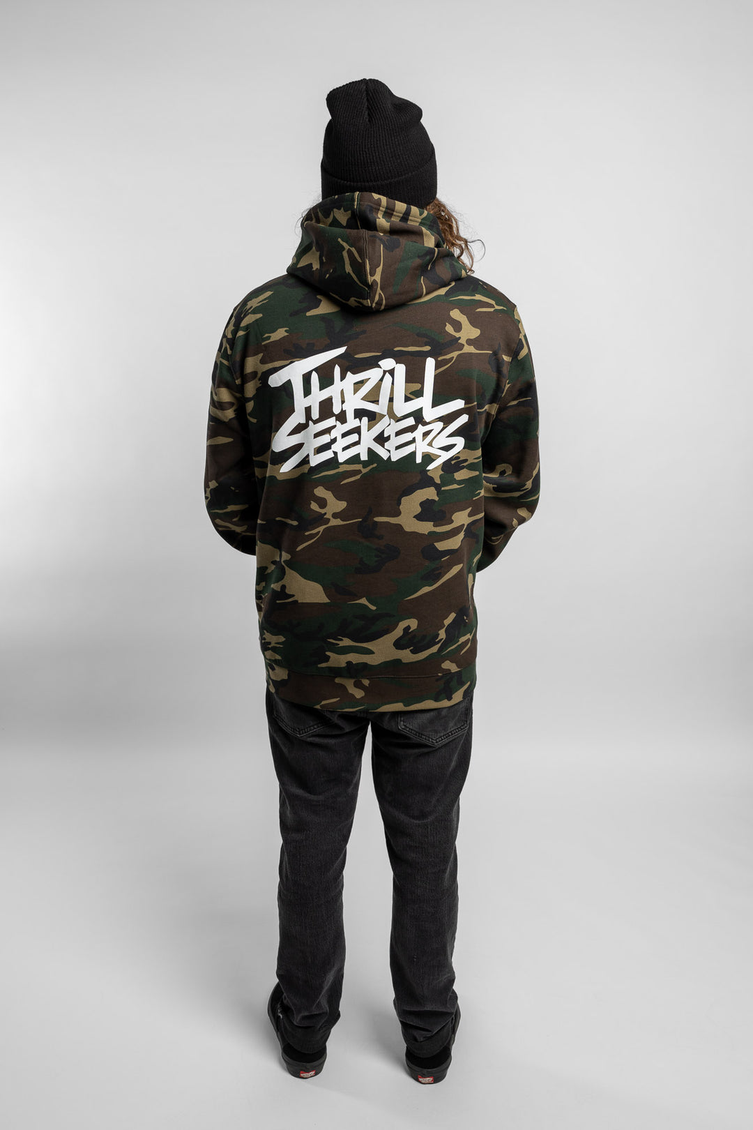 Person wearing camo hoodie with 'Thrill Seekers' logo in white