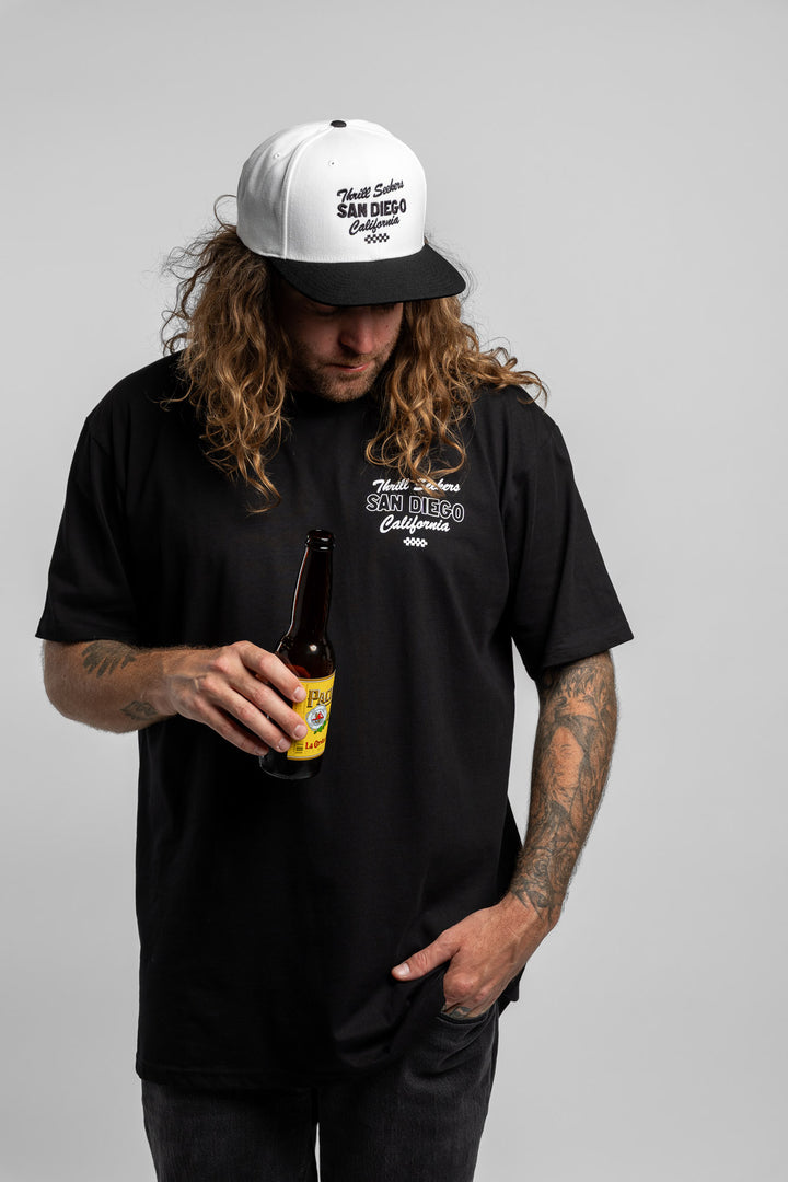 Person wearing black tee with 'Thrill Seekers' shop logo