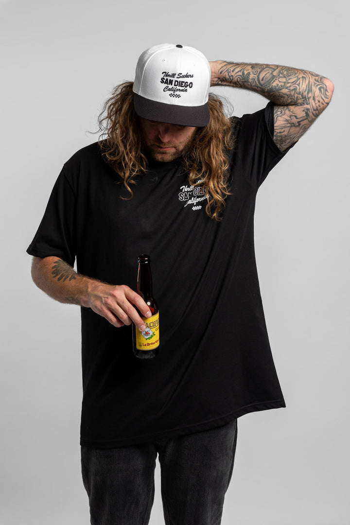 Person wearing black tee with 'Thrill Seekers' shop logo