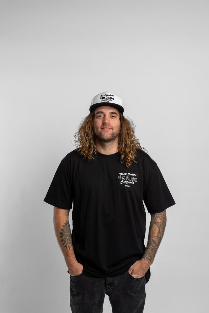 Person wearing black tee with 'Thrill Seekers' shop logo