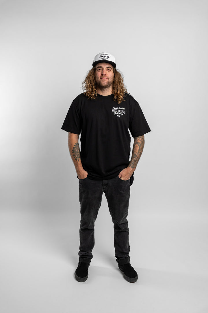 Person wearing black tee with 'Thrill Seekers' shop logo