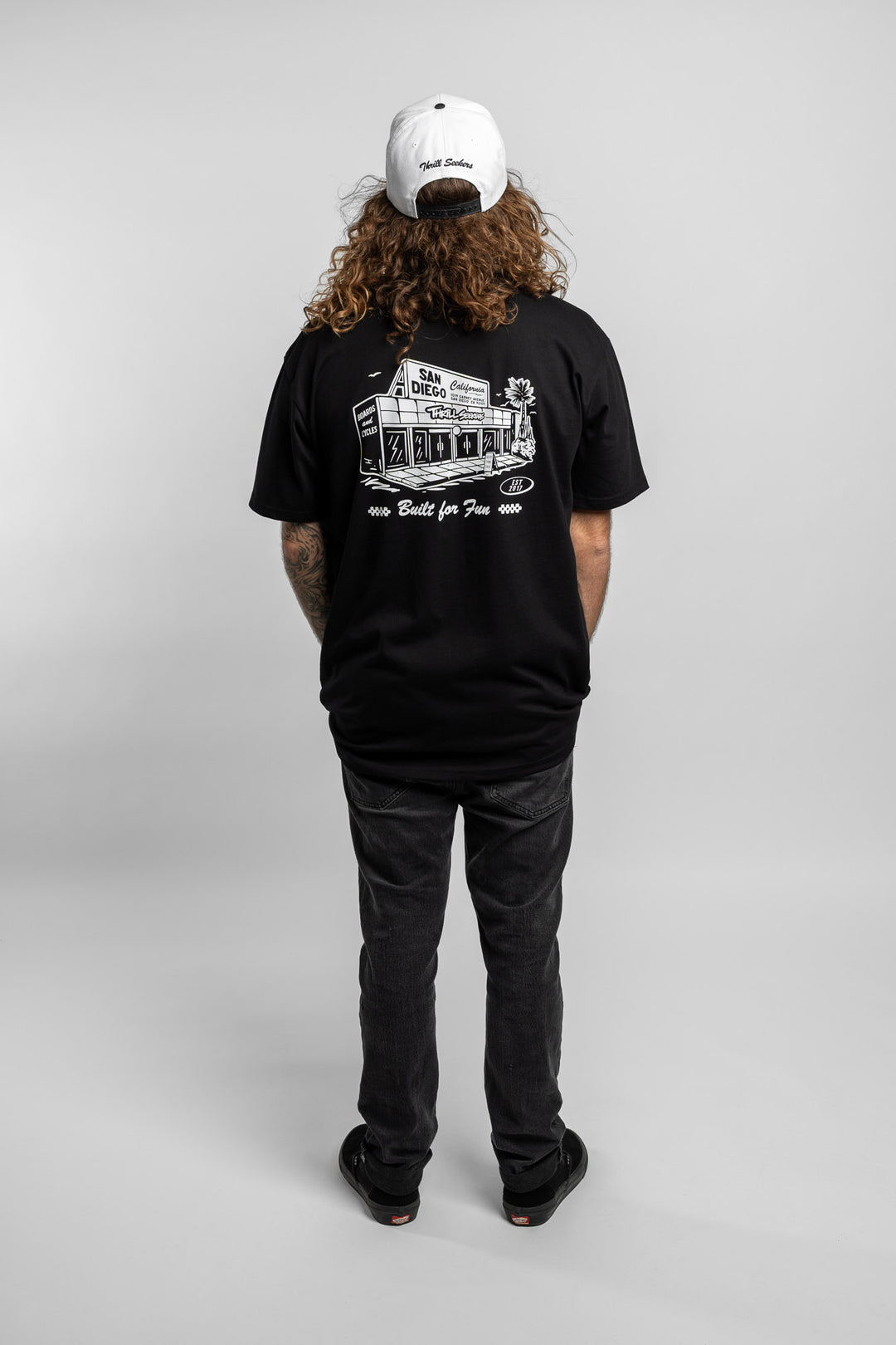 Person wearing black tee with 'Thrill Seekers' shop logo