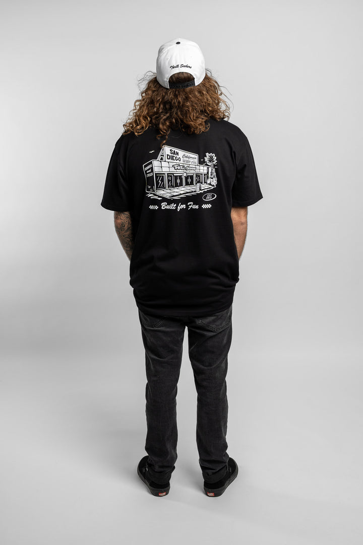 Person wearing black tee with 'Thrill Seekers' shop logo