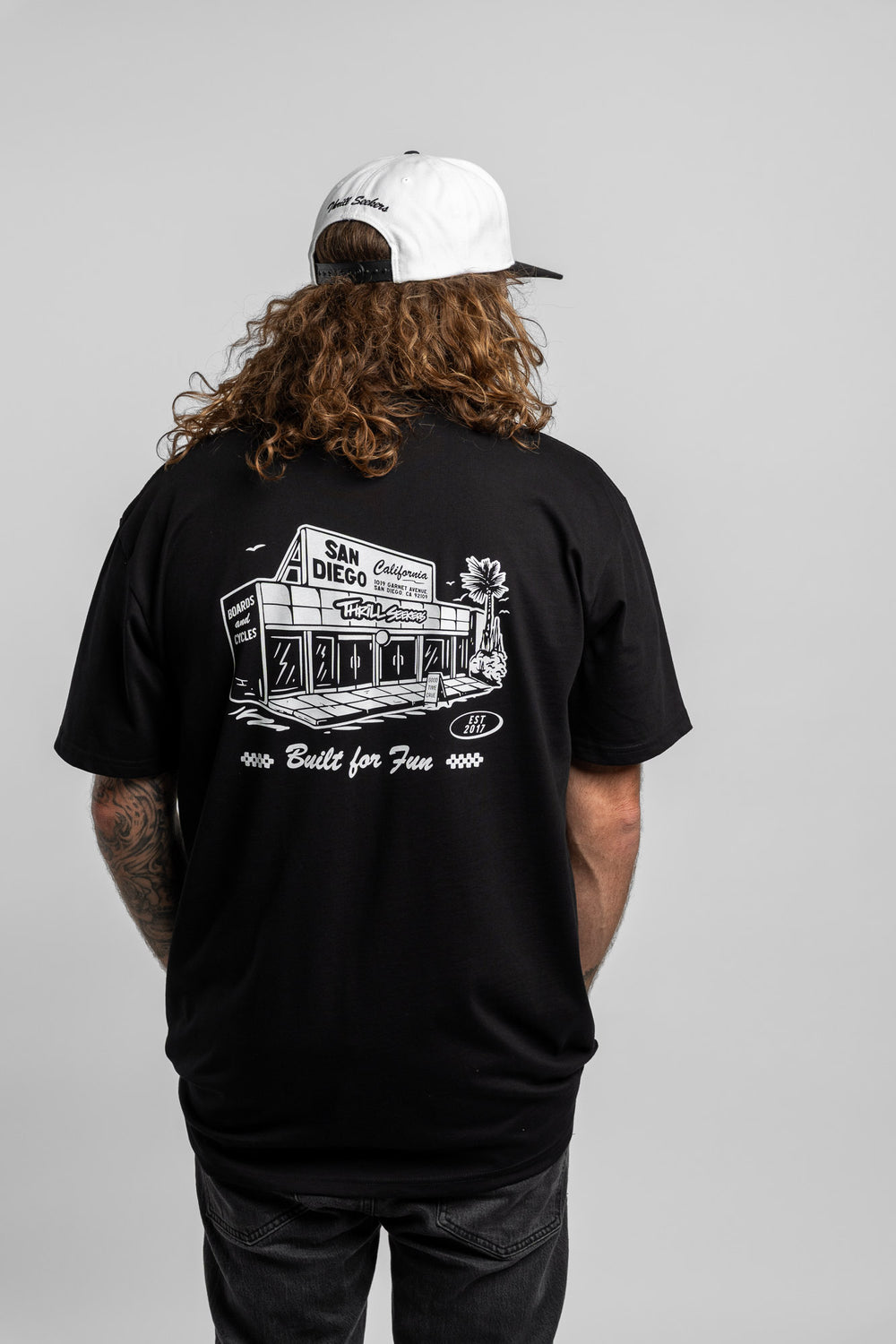 Person wearing black tee with 'Thrill Seekers' shop logo